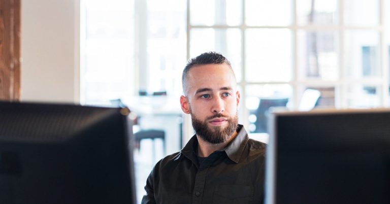 Man-with-beard-looking-at-computer