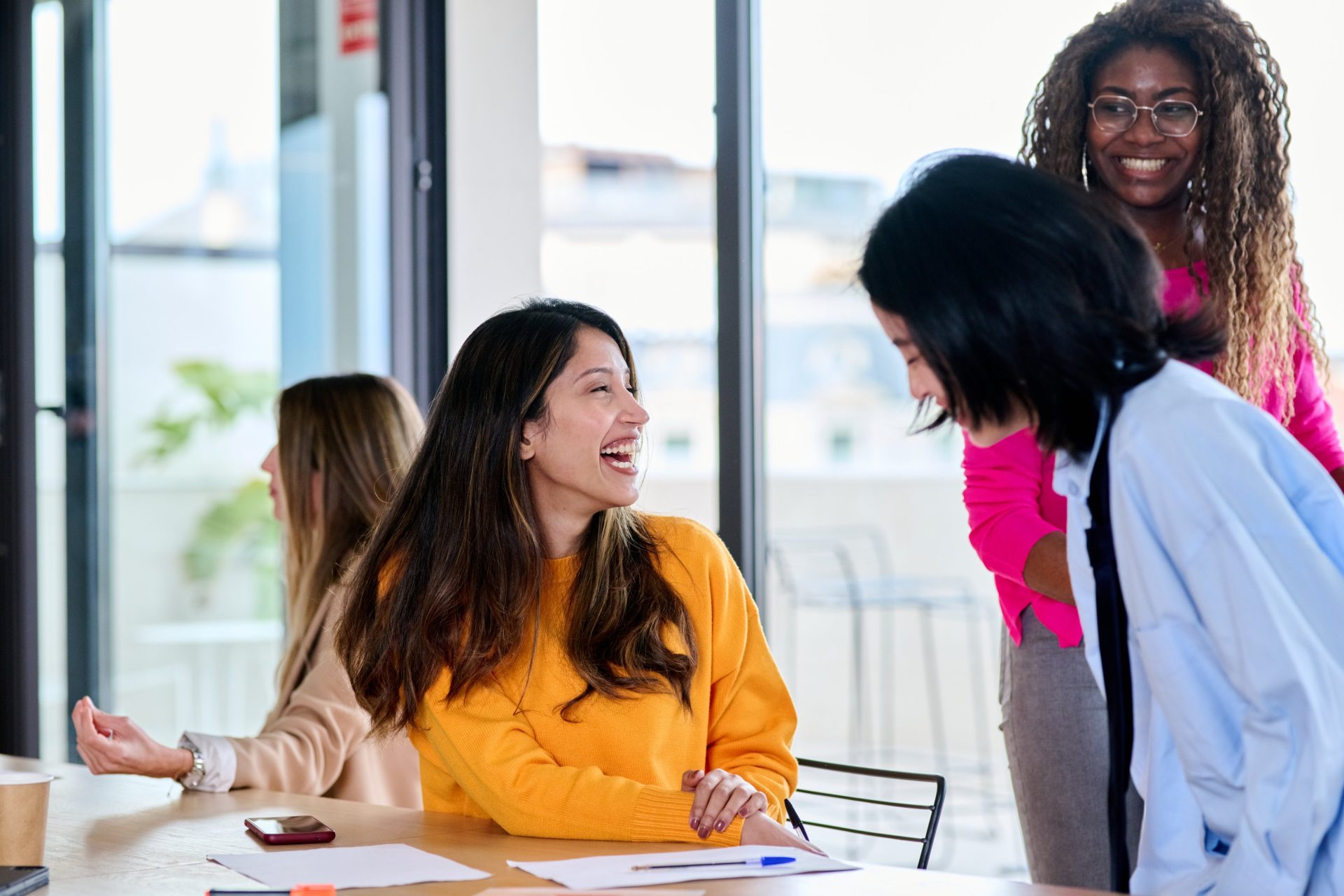 Businesswomen laughing together in the office.